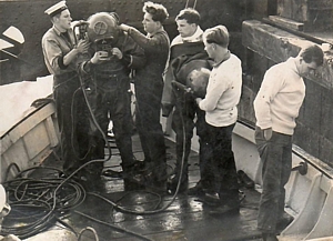 Divers donning Mine Recovery Suit (MRS) rigged for surface supply