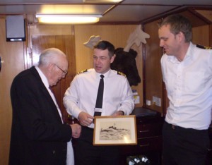 Jack Roberts presents the CO of the current HMS Cattistock with a picture of her predecessor